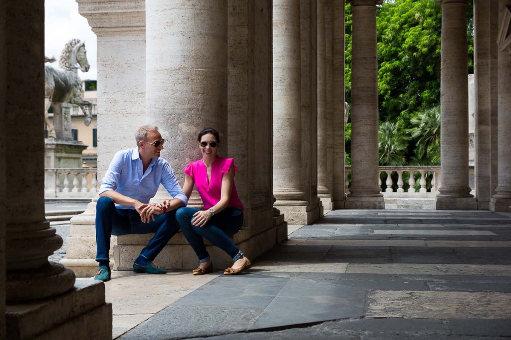 Couple sitting down during under the columns of Piazza Campidoglio