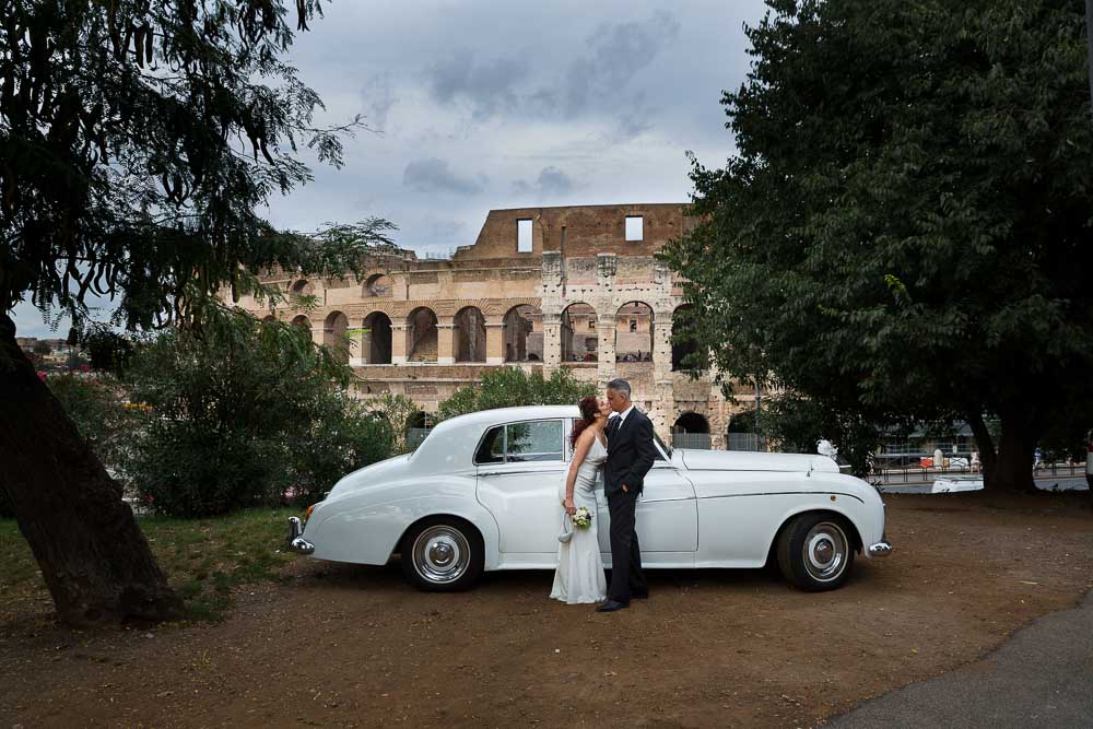 Pictures taken by the vintage Rolls Royce car placed in front of the Coliseum in Rome Italy.