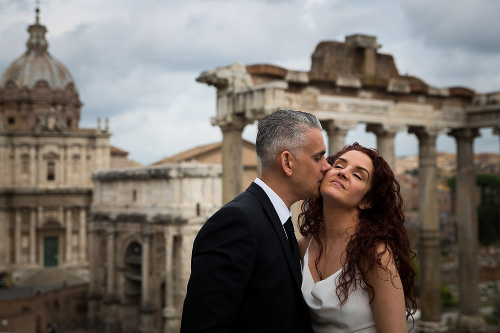 Groom kissing the bride aster the wedding by the Roman Forum.