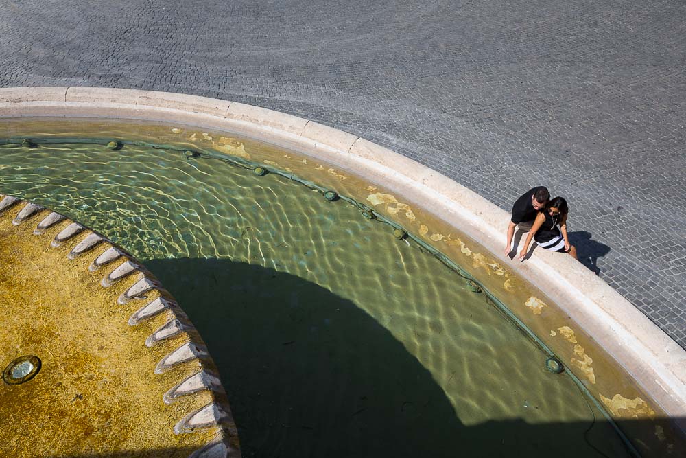 Artistic image of a couple over a water fountain in Piazza del Popolo