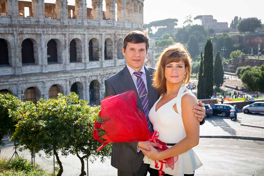 Couple posing in front of the Colosseum in Rome Italy during a photo tour.