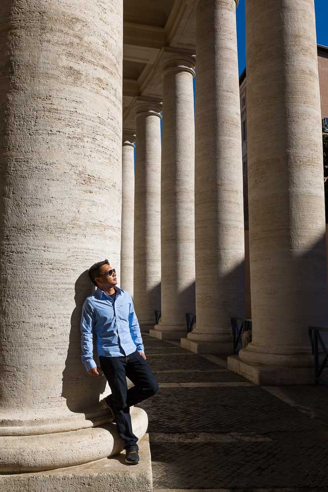 Man posing while leaning on a column