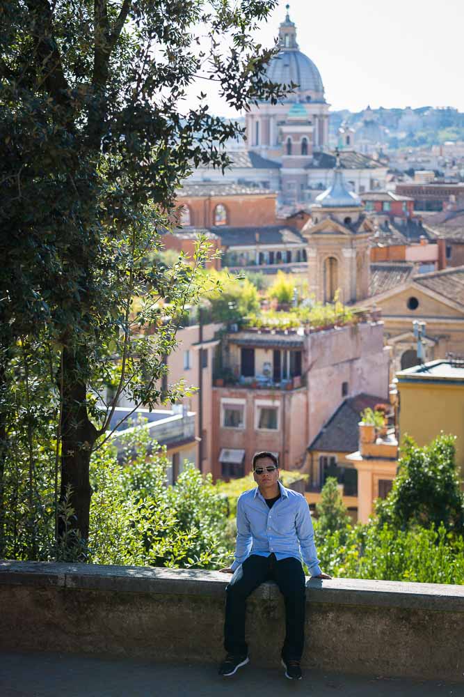 Sitting down before the rooftop view of the houses in Rome.