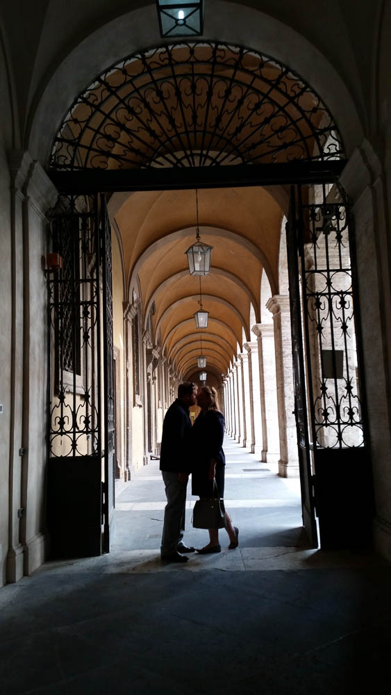 Kissing under portico. Rome Honeymoon Photo Tour.
