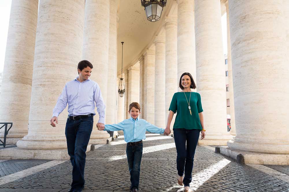 Rome family photo session walking together under the columns of St. Peter