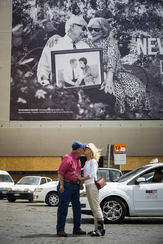 Kissing underneath a publicity billboard poster 