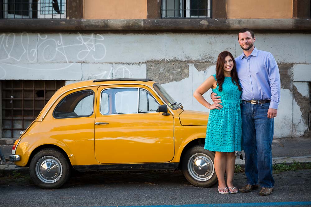 Couple standing in front of an Italian vintage car during a photo shoot