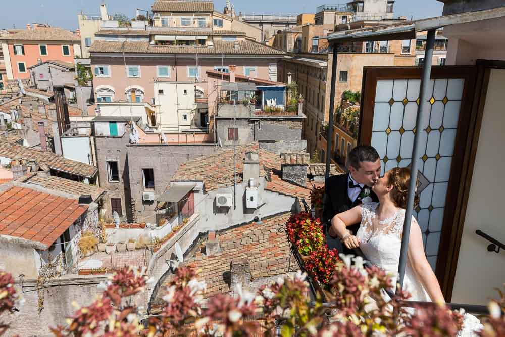 Bride and groom kissing on top of the Rome rooftops