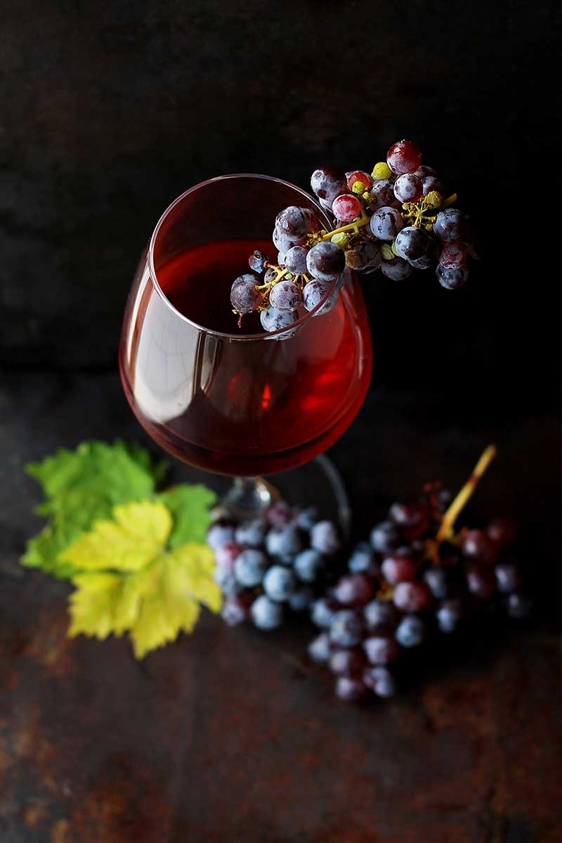 Red wine glass view from above together with red grapes